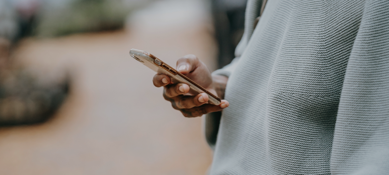 Mão negra segurando um smartphone.